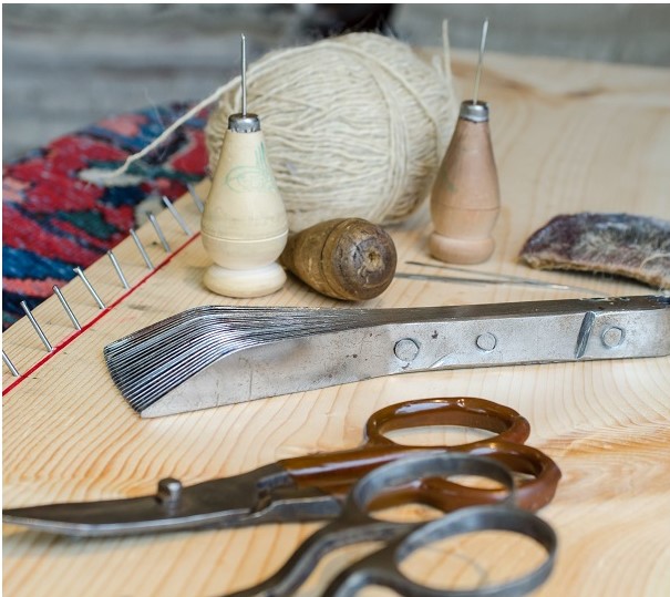 Hand tools for preparing and restoring rugs, including brush.